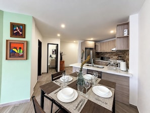 A modern kitchen with wooden cabinets, a stainless steel refrigerator, and a microwave.