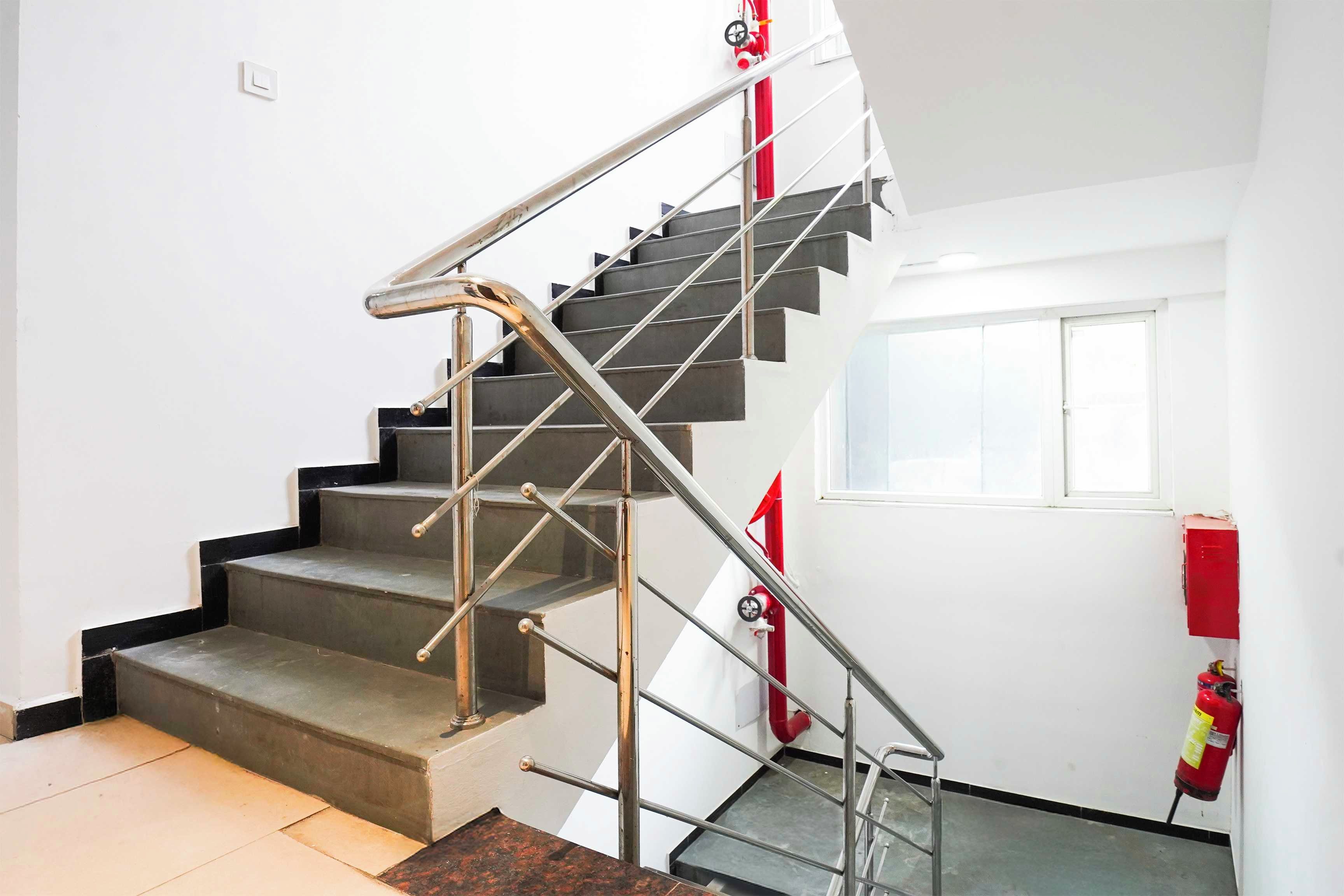 Eine Treppe mit Metallgeländern und einem Feuerlöscher an der Wand.