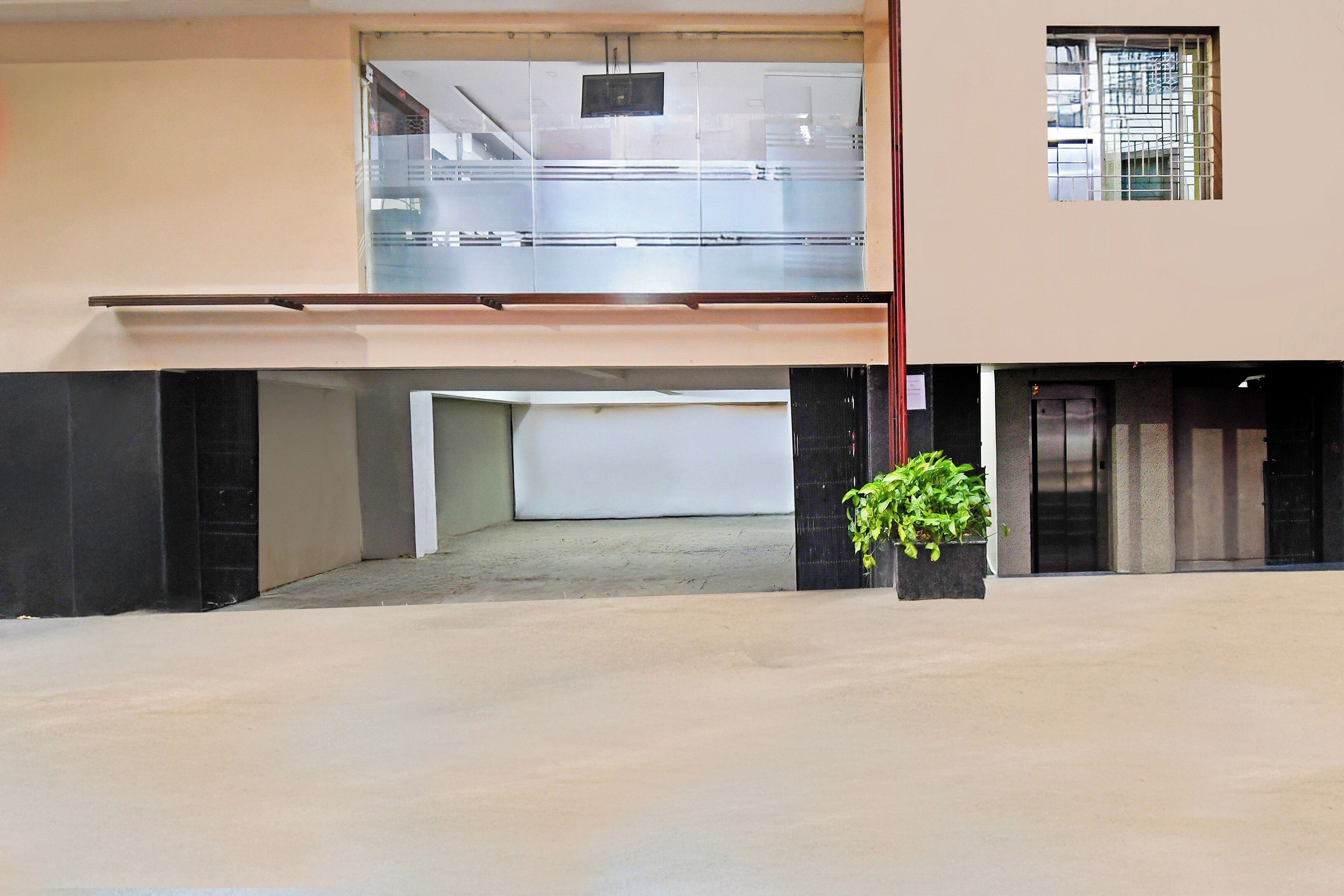 A building with a garage entrance, a staircase, and a small window.