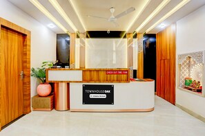 A reception desk with a 'TOWNHOUSE OAK' sign, a ceiling fan, and a check-out time of 11 AM.