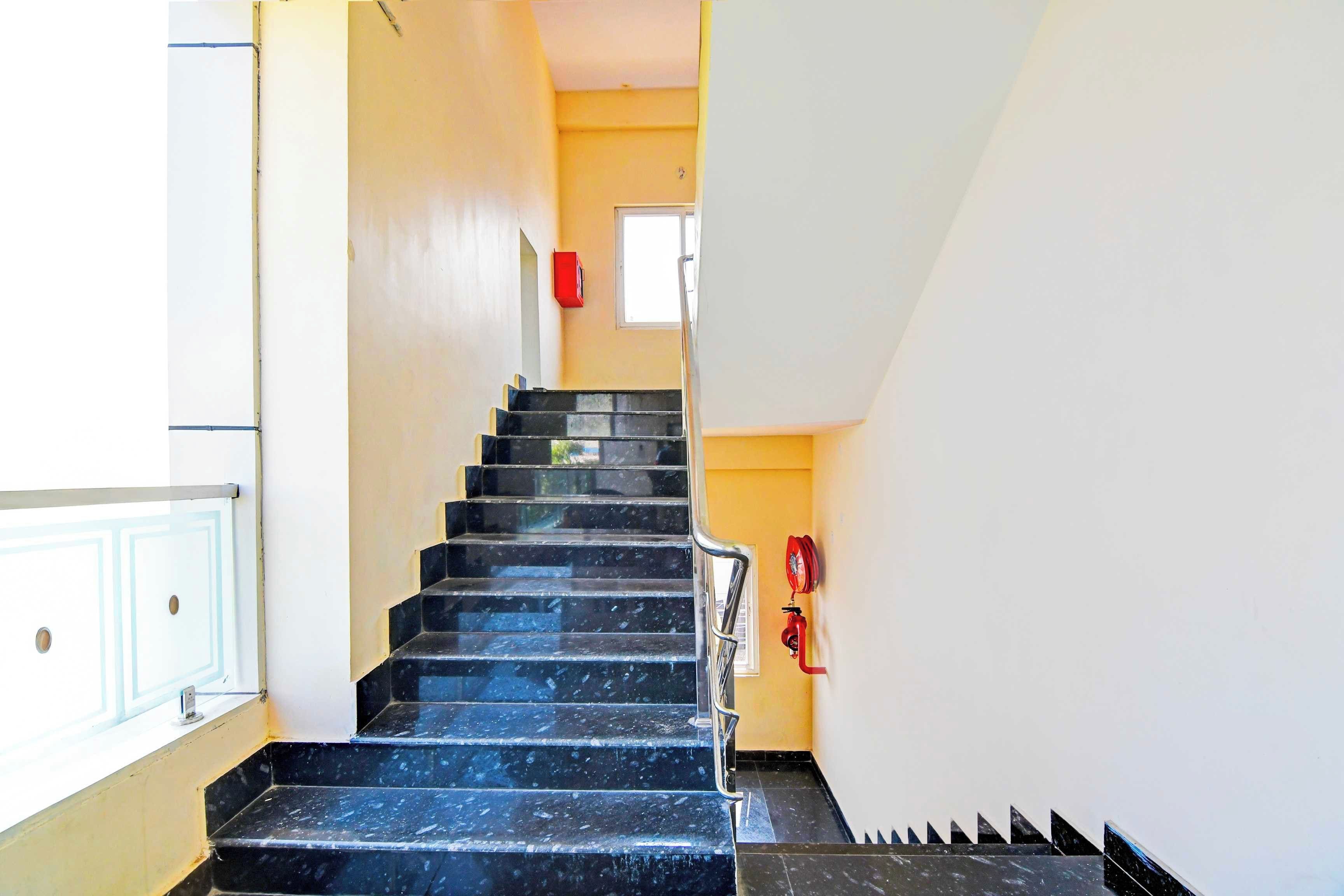 Una escalera con escalones negros que lleva a una plataforma.