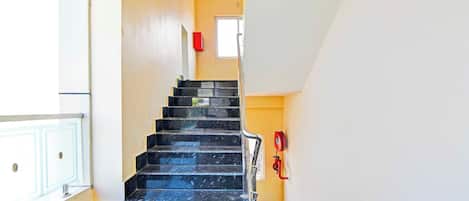 A staircase with black steps leading to a landing.