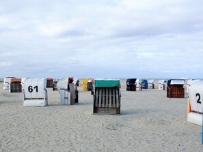 Beach huts numbered 61 and 2, arranged in rows on a sandy beach. - 47.1.s Waterkant (Wangerland)