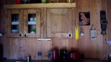 Een houten keuken met een spoelbak, fornuis en kastjes.