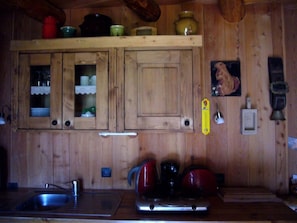 A wooden kitchen with a sink, stove, and cabinets. - Le Marmotton Gîte – Chalet Les Abeillos, Mountain View Retreat for 2 (Bonneval-sur-Arc)