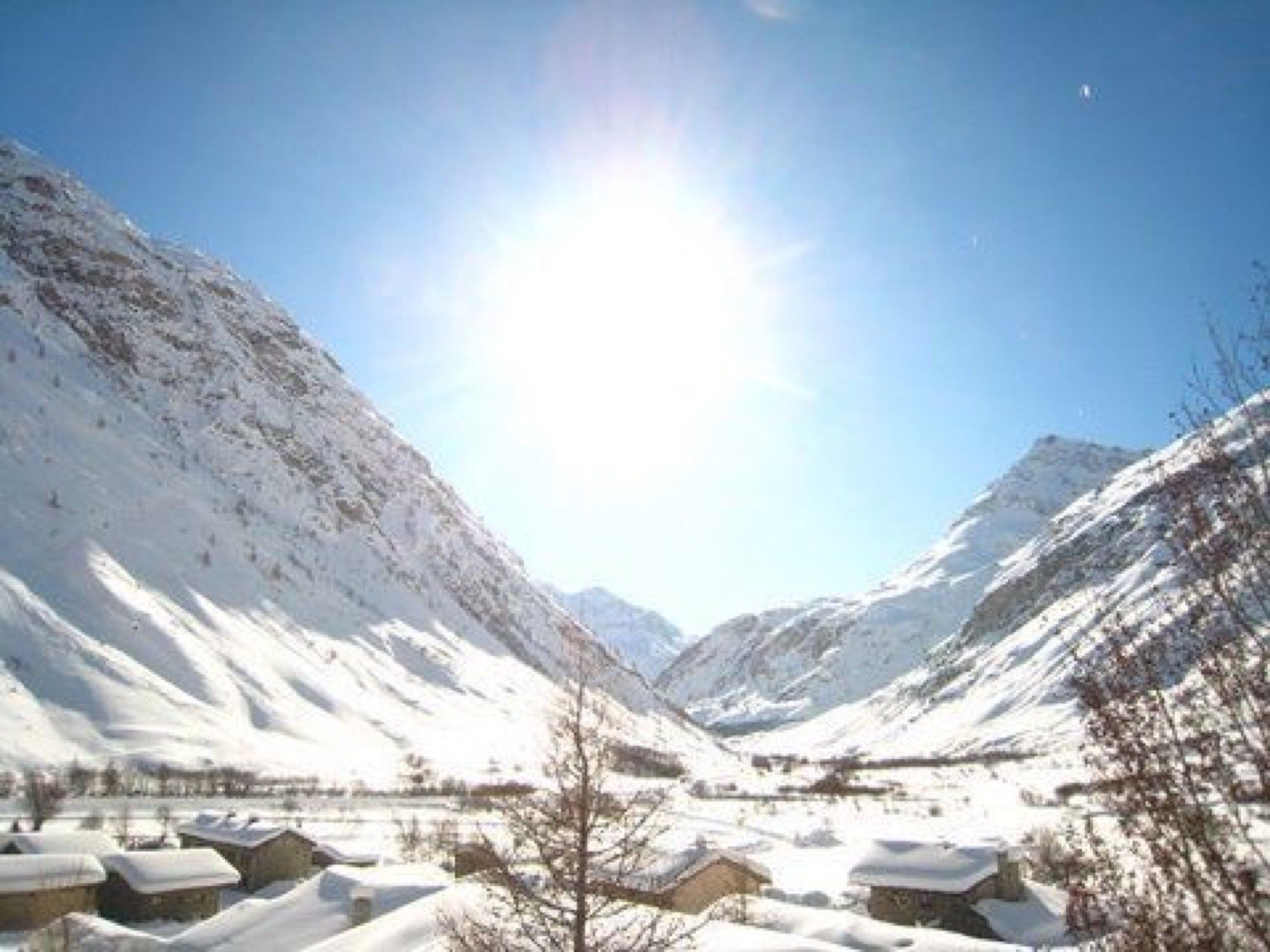 Un paysage de montagne enneigé, sous un ciel dégagé.