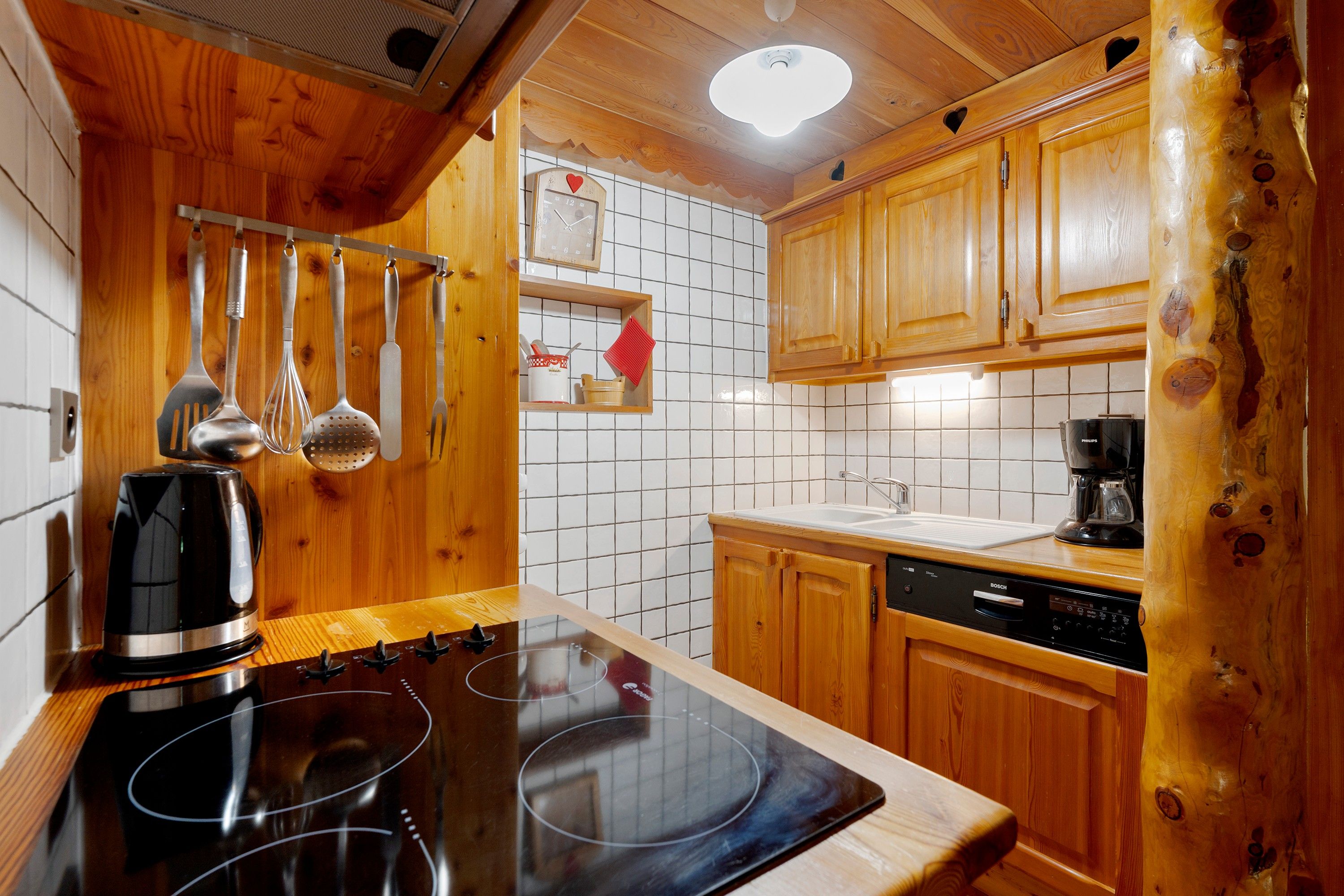 A kitchen with wooden cabinets, a Bosch dishwasher, and a stove.