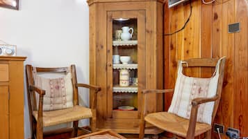 A traditional room with wooden furniture, including two chairs and a cabinet with glass doors.