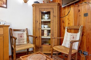 A traditional room with wooden furniture, including two chairs and a cabinet with glass doors.