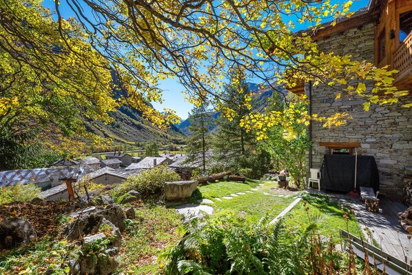 A rustic stone building with a stone wall and a wooden deck.