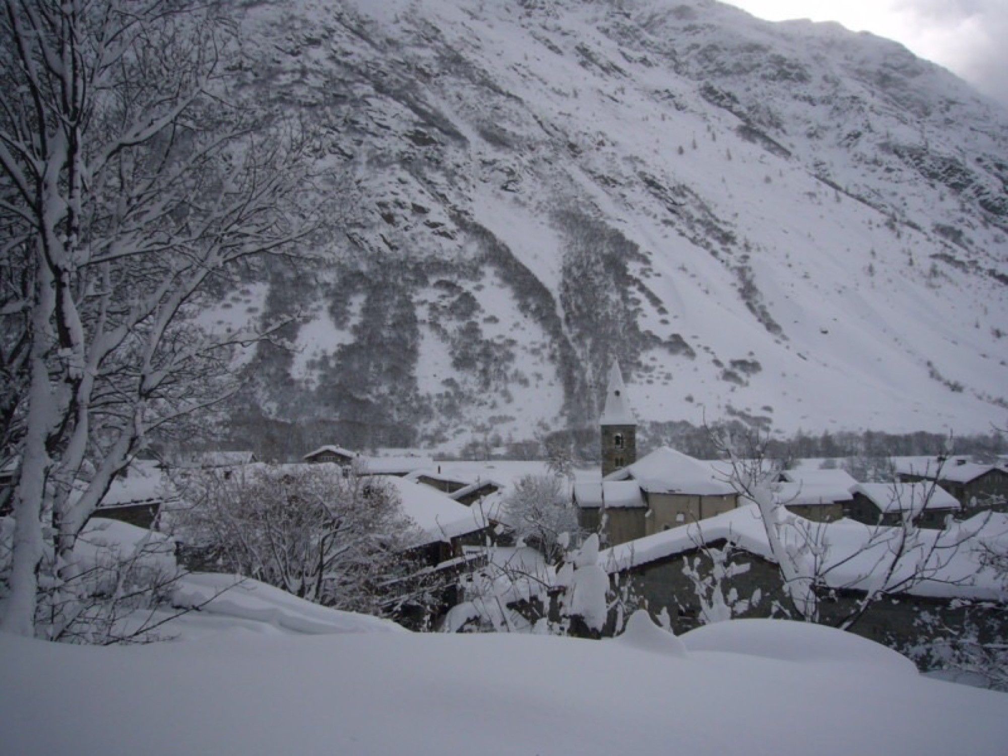 A snow-covered mountain with buildings at its base.
