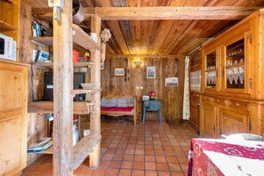 A rustic wooden interior with a bed, shelves, and a small table. - Gîte l'Erablo – Chalet Les Abeillos in Bonneval-sur-Arc, Vanoise National Park (Bonneval-sur-Arc)