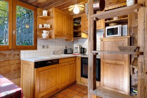 A wooden cabin kitchen with a sink, stove, and cabinets. - Gîte l'Erablo – Chalet Les Abeillos in Bonneval-sur-Arc, Vanoise National Park (Bonneval-sur-Arc)