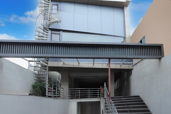 A modern building with a staircase leading to a garage entrance.