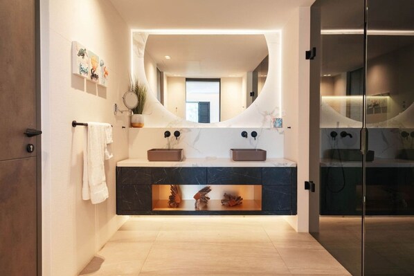 A modern bathroom with a marble vanity, a large mirror, and a glass shower enclosure. - LUX 2BR Villa w/ Ocean View • The Shore Unit 30 by Bocobay (Willemstad)