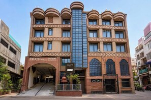 Un hotel con entrada central, varios pisos y una fachada moderna.