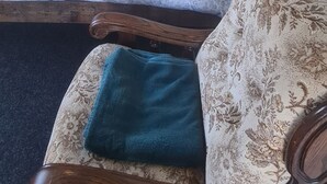 Un dormitorio con una cama, una silla, una escalera de madera y una puerta.