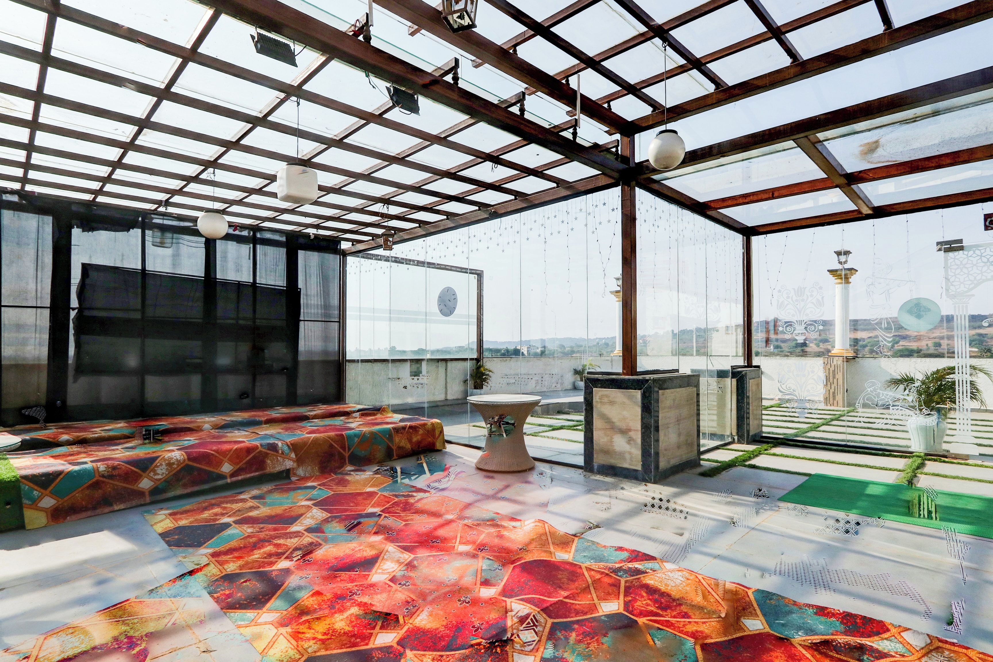 Une pièce spacieuse avec une grande fenêtre, un sol à motifs et un coin salon.