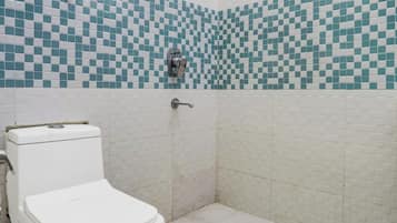 A bathroom with a toilet, a shower, and tiled walls.