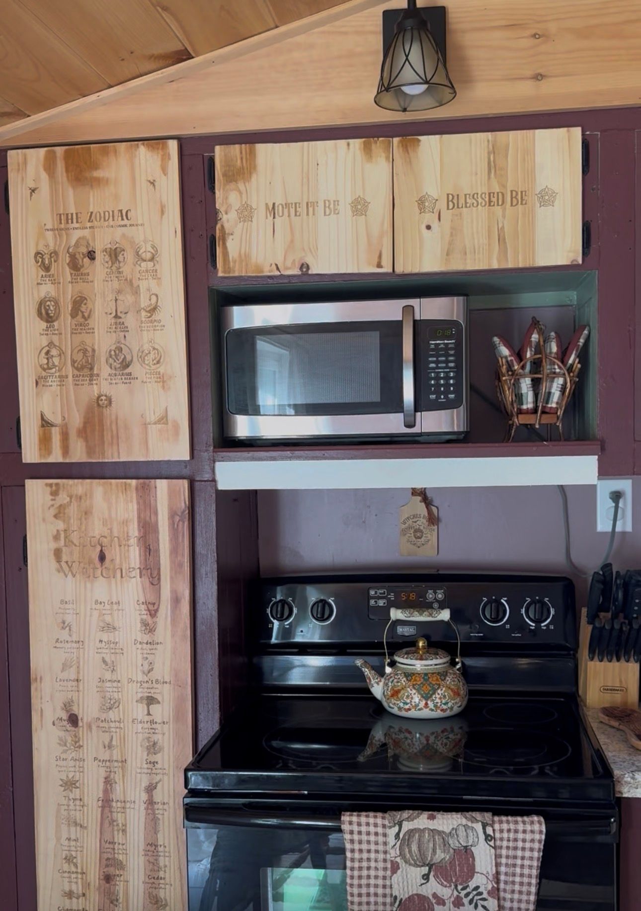 Une cuisine équipée d’un four à micro-ondes, d’une cuisinière et agrémentée de décorations murales en bois.