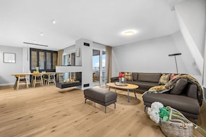 Ein moderner Wohnraum mit Essbereich, einer Sofagarnitur und einem Kamin.