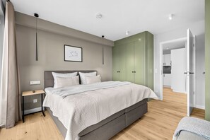 Ein modernes Schlafzimmer mit Bett, Nachttisch und Kleiderschrank.