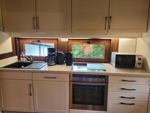 A kitchen with a coffee maker, microwave, and oven. - Experience pure relaxation at the family-friendly KÜSTENKIND vacation home in Burhav (Burhave)