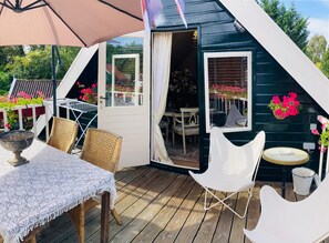 A cozy outdoor seating area with a table, chairs, and a large umbrella. - Apartment for 4 people with a private sauna by the water, breakfast service, and parking (Bruinisse)