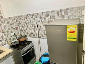 A kitchen with a stove, oven, and refrigerator. - Contemporary City Flat with Comfortable Bedroom & Spacious Living Area (Accra)