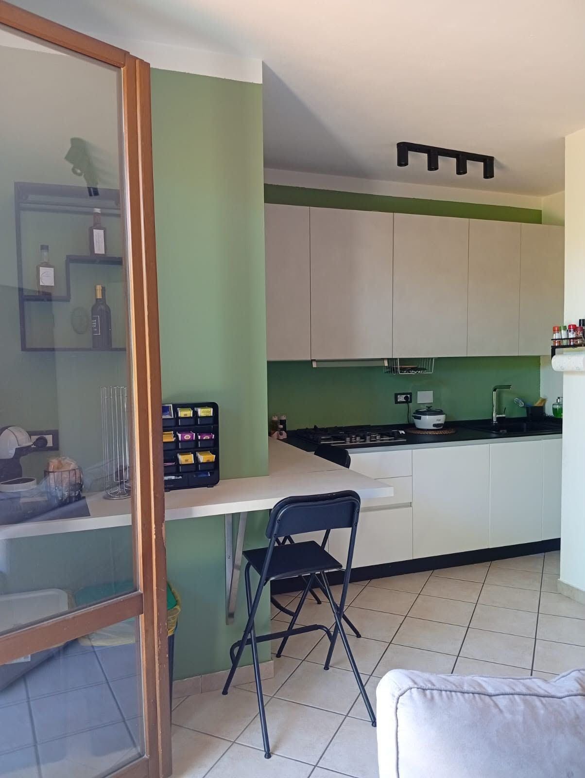A compact kitchen with a dining area, a small table, and a chair.