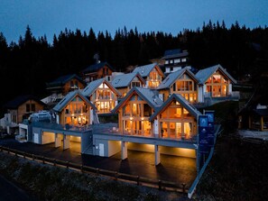A multi-story lodge with a central atrium, surrounded by forested hills. - Chalet #1 With 2 Bedrooms and Sauna (Oberwölz)