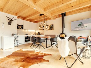 A modern kitchen with white cabinets, a wooden ceiling, and a mounted deer head. - Chalet #1 With 2 Bedrooms and Sauna (Oberwölz)