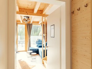 A wooden interior with a staircase leading to a balcony, a bed, and a seating area with a view of the outdoors. - Chalet #1 With 2 Bedrooms and Sauna (Oberwölz)