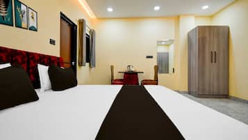 Una habitación de hotel con cama, escritorio, armario y espejo.