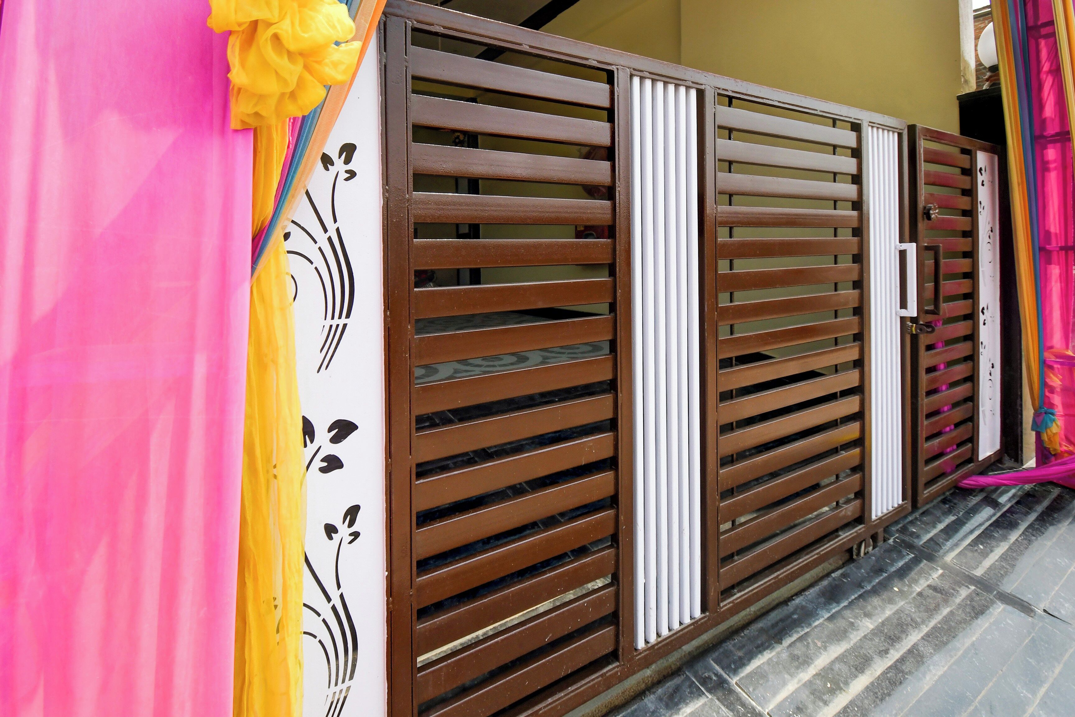 Una entrada cerrada con un portón metálico y un panel decorativo a la izquierda.