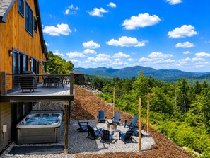 A wooden cabin with a hot tub and outdoor seating area overlooking a mountainous landscape. - Luxury Mountain Escape • 6BR • Hot Tub & Views • 4mi to Sunday River (Bethel)