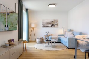 Ein modernes Wohnzimmer mit einer Couch, einem Couchtisch und Kunstwerken an der Wand.