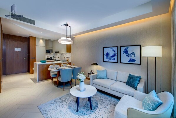 Une chambre d’hôtel moderne avec un coin repas, un ensemble de canapés et des œuvres d’art accrochées au mur.