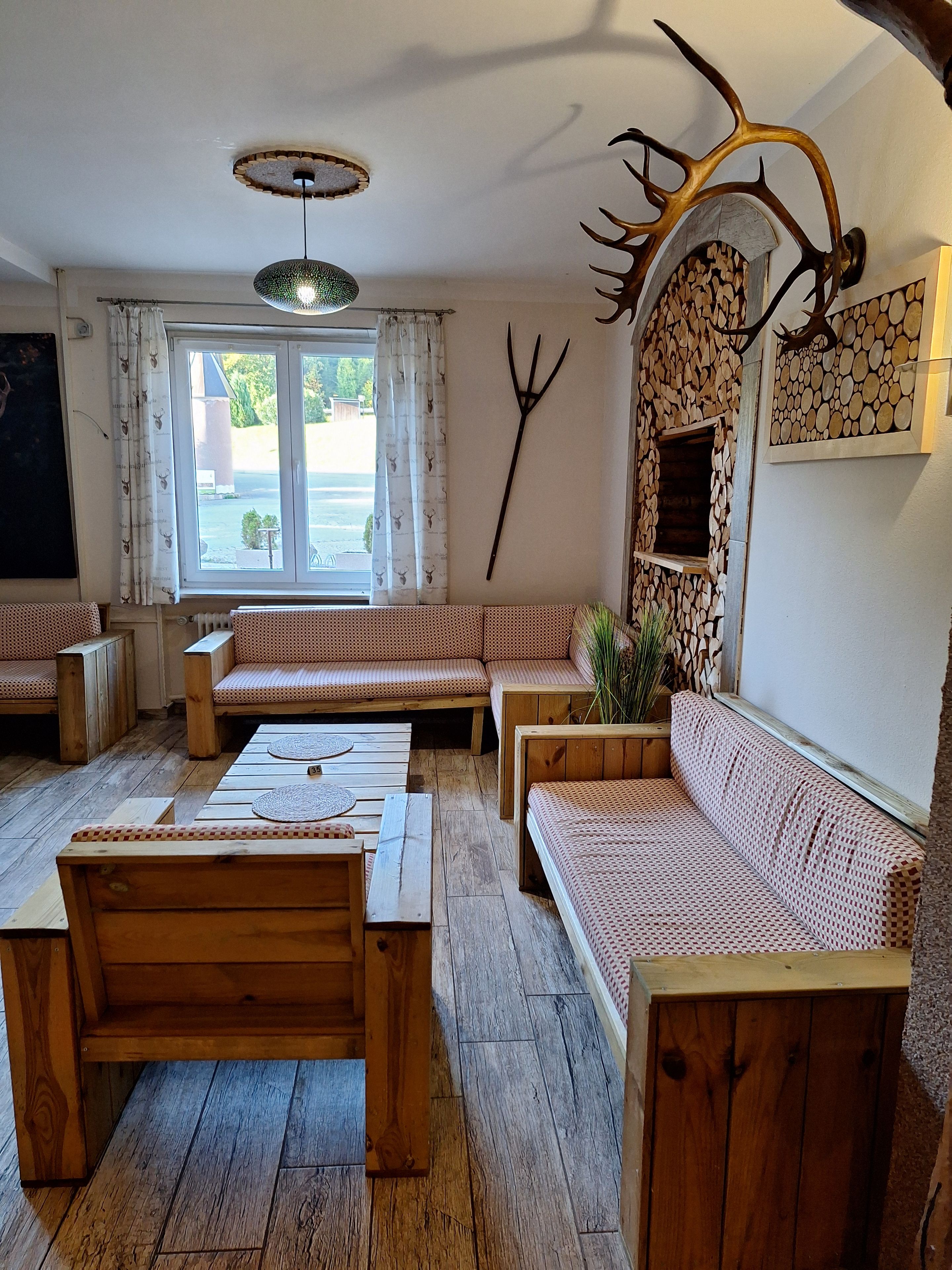 A cozy room with a wooden bench seating area, a dining table, and a rustic wall decoration.