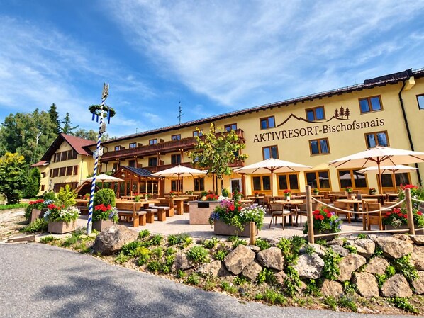 A building with outdoor seating and a sign that reads 'AKTIVRESORT-Bischofsmais.'