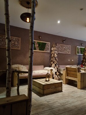 A cozy room with a sofa, a wooden bench, a lantern, and wall art.