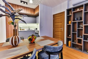 Un comedor con una mesa de madera, sillas, un frutero y una planta decorativa.