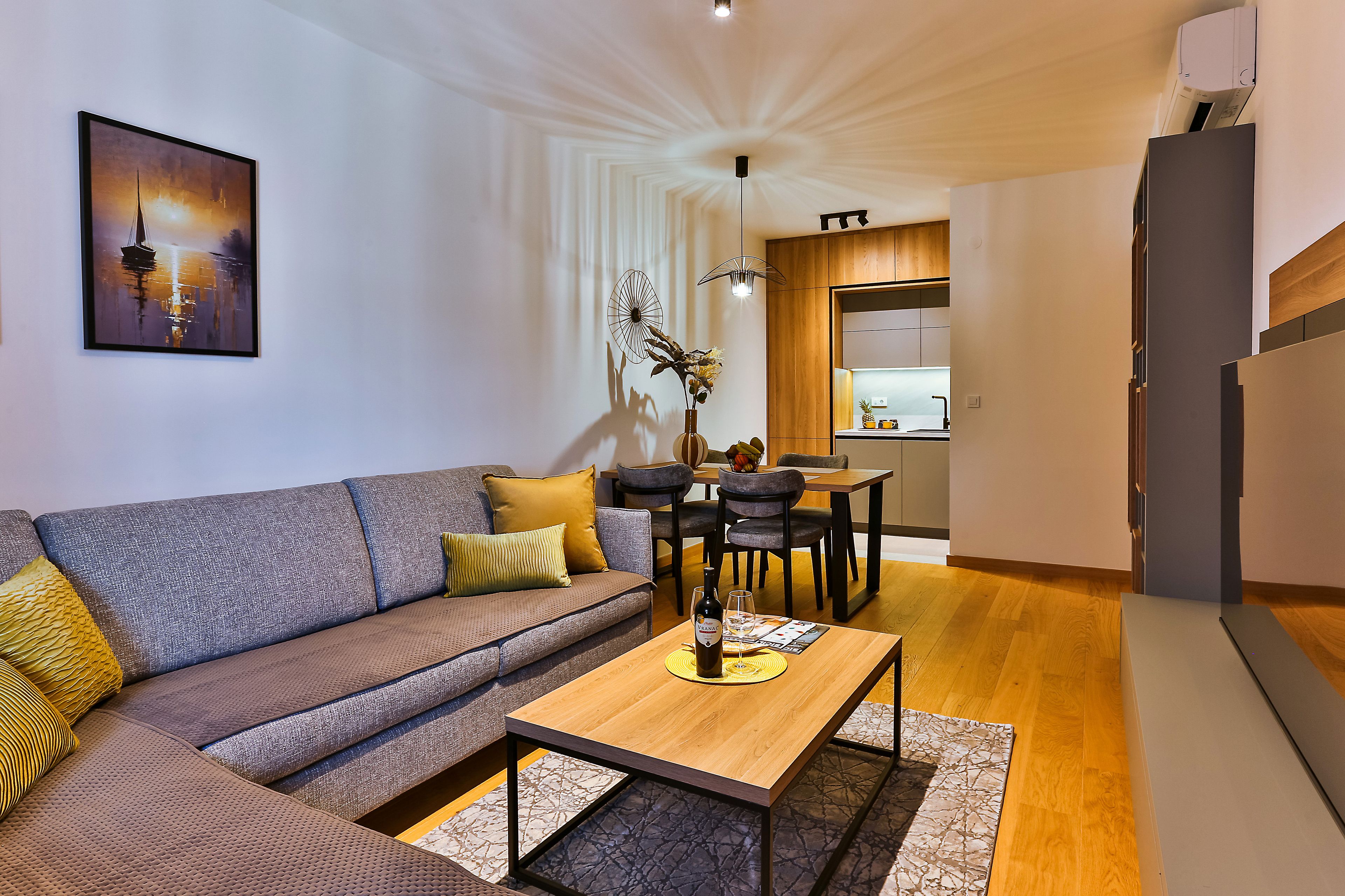 Un salon moderne avec un canapé, une table basse et un coin repas avec des chaises.