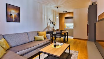 Ein modernes Wohnzimmer mit einer Couch, einem Couchtisch und einem Essbereich mit Stühlen.