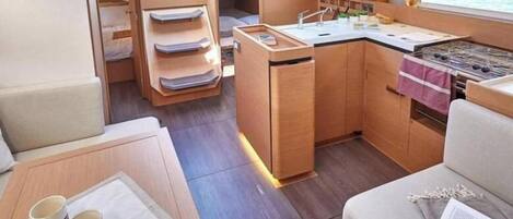 A compact kitchen with a stove, sink, and storage cabinets.