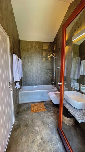 Ein modernes Badezimmer mit einer Badewanne, einem separaten Waschbecken und einer Dusche.