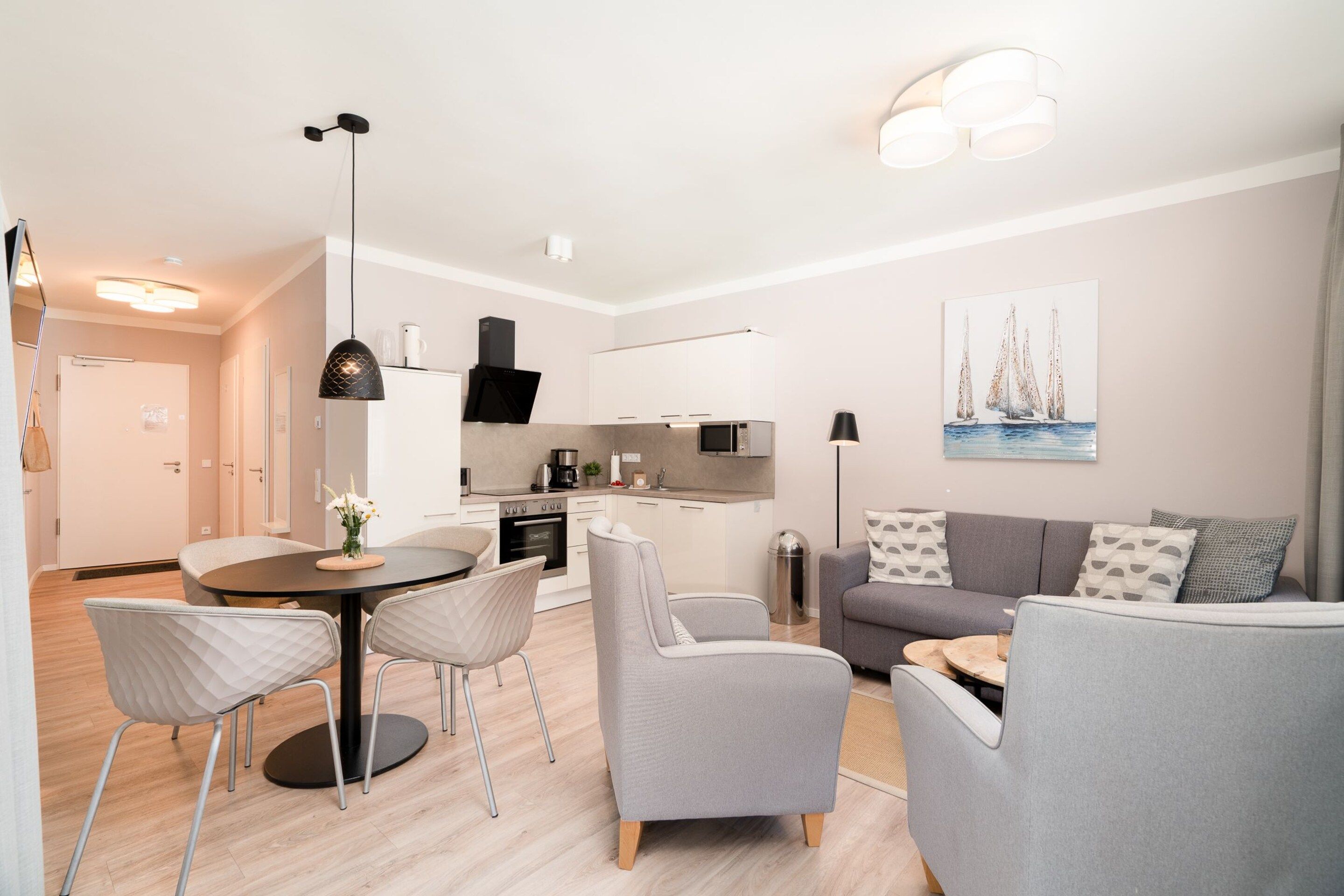 A modern living room with a dining area, a kitchen, and a hallway.