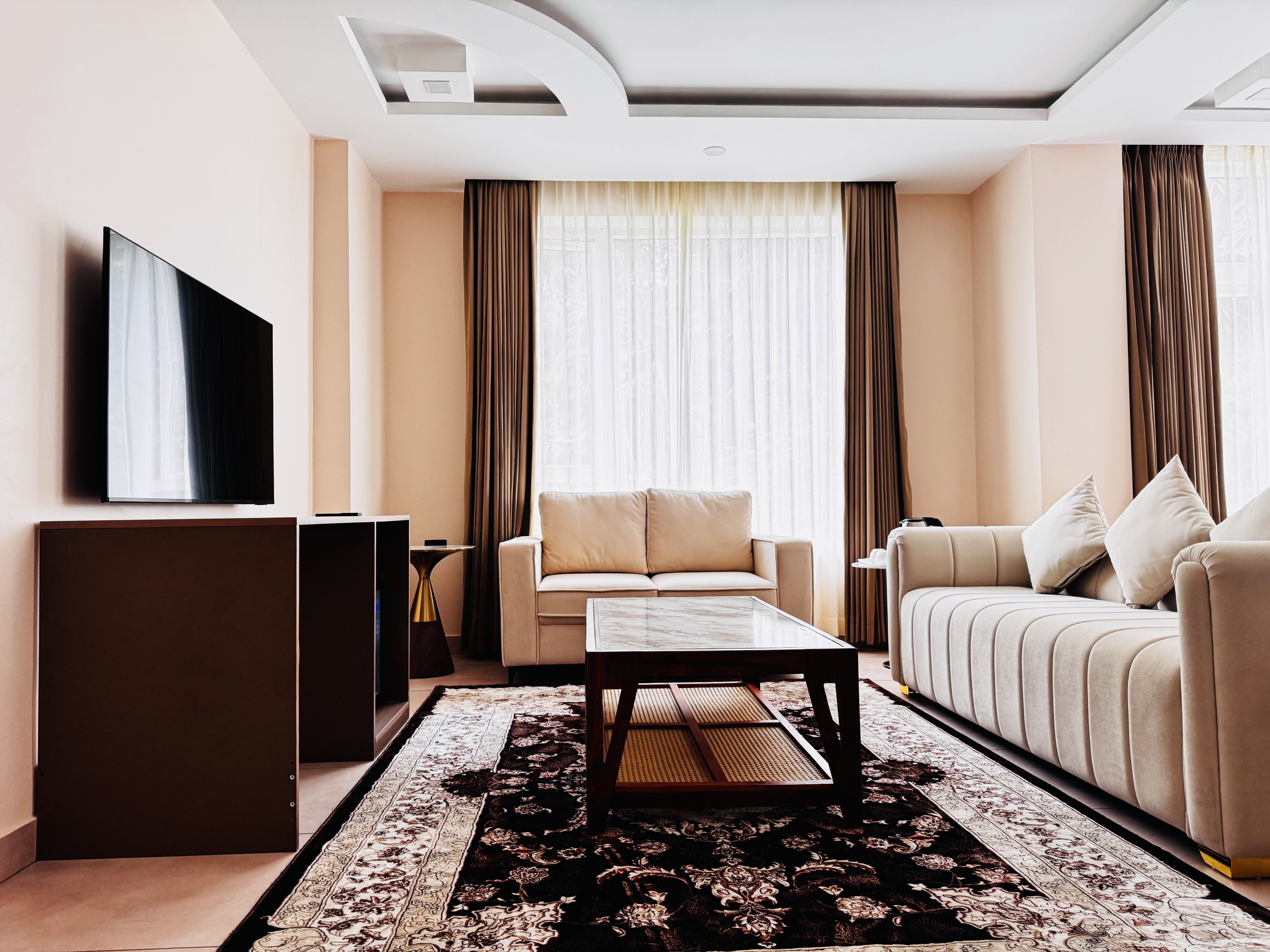 Un salon moderne avec un canapé, une table basse et un téléviseur à écran plat.