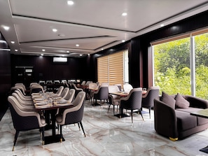 A conference room with a long table, multiple chairs, and a sofa.