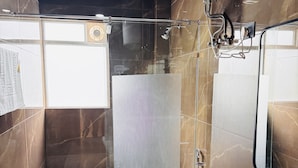 Een moderne badkamer met een douchecabine van glas, een toilet, een wastafel en een bad.